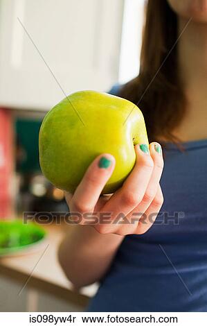 Teenage girl holding green apple View Large Photo Image Stock Photography - Teenage girl holding green apple. Fotosearch