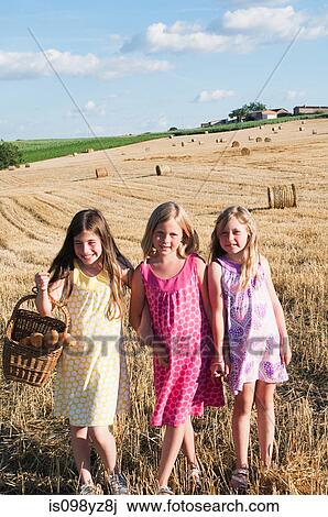 Three girls standing in field, portrait View Large Photo Image Stock Image - Three girls standing in field, portrait. Fotosearch