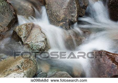 Stock Image - Water flowing over rocks. Fotosearch