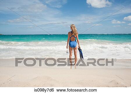 Stock Photograph - Woman at water's edge, Mustique, Grenadine Islands. Fotosearch