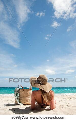 Woman lying on sandy beach, Mustique, Grenadine Islands View Large Photo Image Stock Photograph - Woman lying on sandy beach, Mustique, Grenadine Islands. Fotosearch