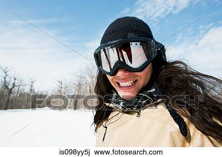 Stock Image - Woman wearing ski goggles, portrait. Fotosearch