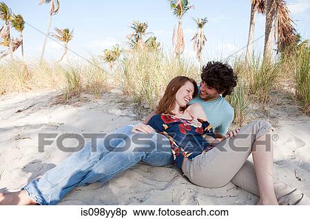 Young couple lying on beach, portrait View Large Photo Image Stock Photography - Young couple lying on beach, portrait. Fotosearch