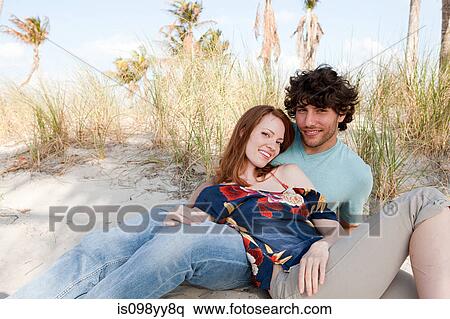 Young couple lying on beach, portrait View Large Photo Image Stock Photography - Young couple lying on beach, portrait. Fotosearch