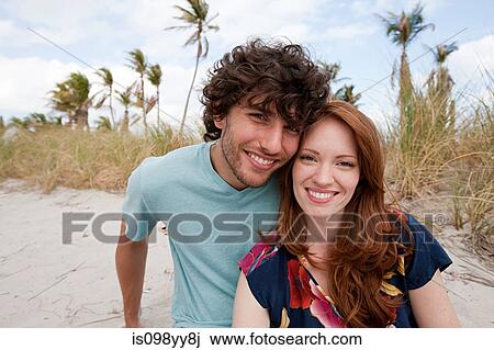 Stock Image - Young couple on beach, portrait. Fotosearch