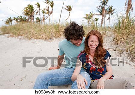 Young couple sitting on beach, portrait View Large Photo Image Stock Image - Young couple sitting on beach, portrait. Fotosearch