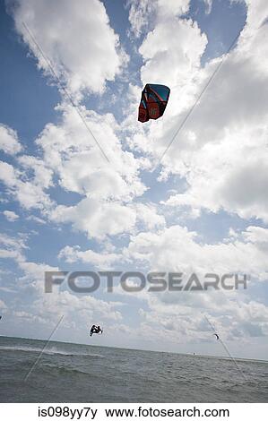 Stock Photo - Young man kitesurfing. Fotosearch