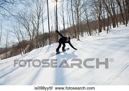 Stock Image - Young man snowboarding. Fotosearch