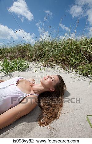 Young woman lying asleep on beach View Large Photo Image Stock Image - Young woman lying asleep on beach. Fotosearch