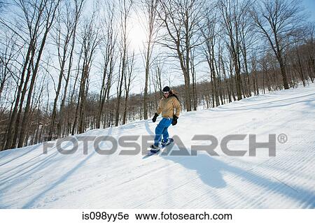 Stock Image - Young woman snowboarding. Fotosearch