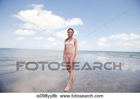 Young woman standing in shallow sea, portrait View Large Photo Image Stock Image - Young woman standing in shallow sea, portrait. Fotosearch