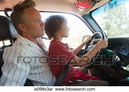 Stock Photography - Boy sitting on man's lap driving car. Fotosearch