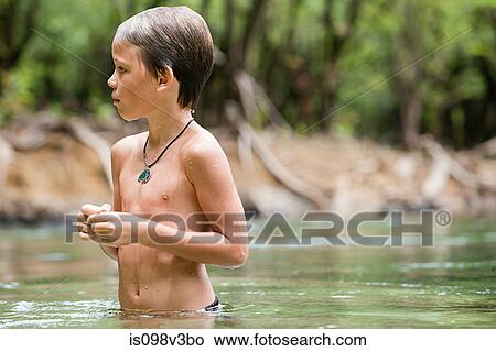 Picture - Boy standing in lake. Fotosearch