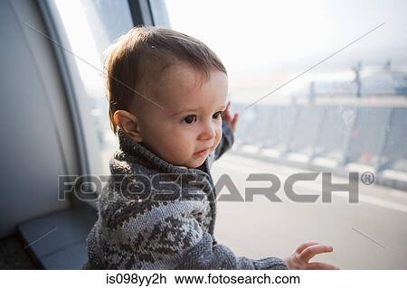 Stock Image - Boy touching airport window. Fotosearch