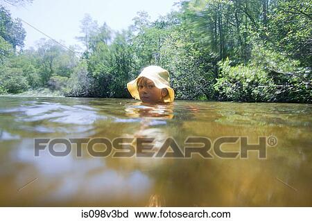 Stock Image - Boy wearing hat in lake. Fotosearch