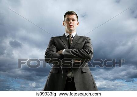 Businessman against storm cloud with crossed arms, low angle View Large Photo Image Stock Image - Businessman against storm cloud with crossed arms, low angle. Fotosearch