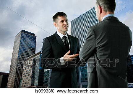Stock Image - Businessmen having conversation. Fotosearch