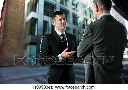 Stock Photo - Businessmen having conversation. Fotosearch