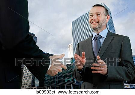Stock Photograph - Businessmen having conversation. Fotosearch