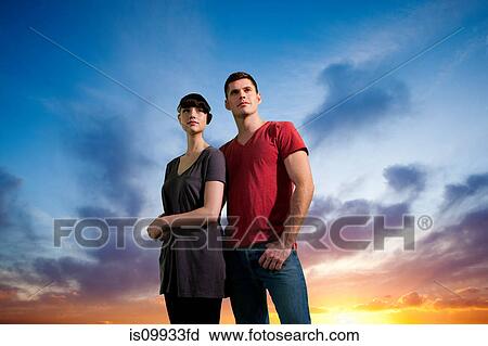 Couple against dramatic sunset View Large Photo Image Stock Image - Couple against dramatic sunset. Fotosearch