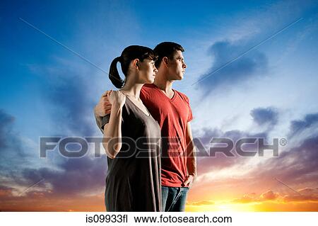 Couple against dramatic sunset View Large Photo Image Stock Image - Couple against dramatic sunset. Fotosearch