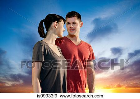 Stock Photo - Couple against dramatic sunset. Fotosearch