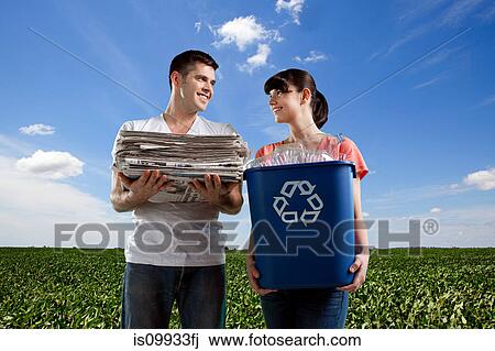 Couple in field holding recycling box and pile of newspapers View Large Photo Image Stock Image - Couple in field holding recycling box and pile of newspapers. Fotosearch