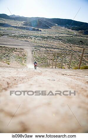 Stock Photo - Man riding dirt bike on dirt track. Fotosearch