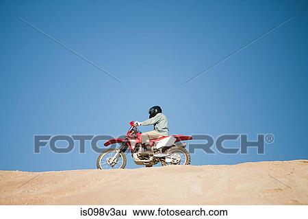 Man riding dirt bike on hill View Large Photo Image Stock Photograph - Man riding dirt bike on hill. Fotosearch