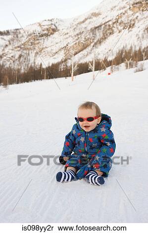 Stock Photography - Portrait of baby boy sitting in snow. Fotosearch