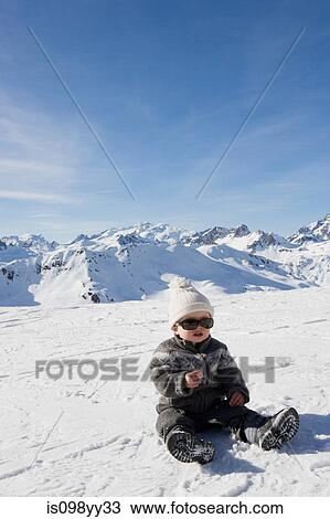 Portrait of boy sitting in snow View Large Photo Image Stock Image - Portrait of boy sitting in snow. Fotosearch