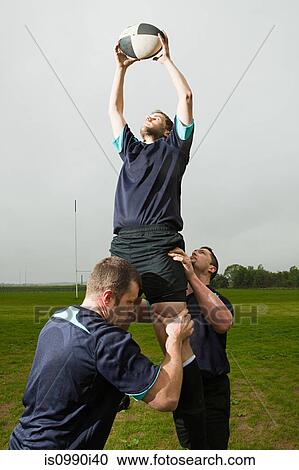 Rugby player jumping to catch ball in lineout, supported by teammates View Large Photo Image Stock Image - Rugby player jumping to catch ball in lineout, supported by teammates. Fotosearch