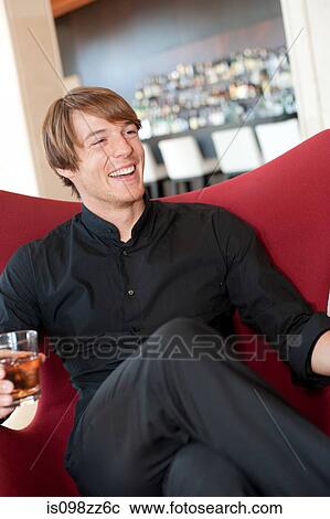 Smiling man in bar with a drink View Large Photo Image Stock Image - Smiling man in bar with a drink. Fotosearch