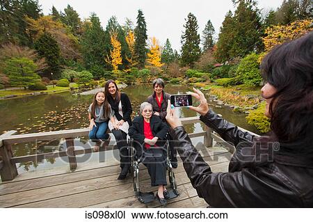 Woman photographing multi generation family View Large Photo Image Stock Image - Woman photographing multi generation family. Fotosearch