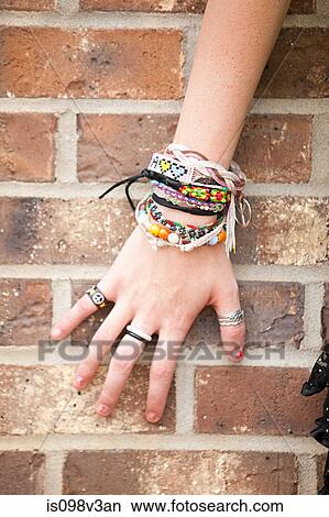 Woman's hand with bracelets by brick wall View Large Photo Image Picture - Woman's hand with bracelets by brick wall. Fotosearch