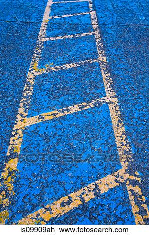 Stock Image - Yellow road marking on blue asphalt. Fotosearch