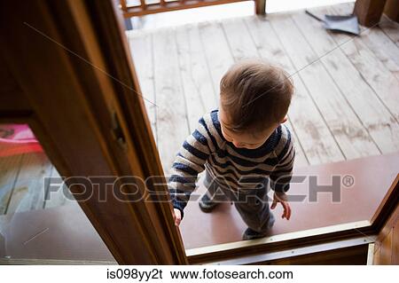 Stock Photograph - Young boy in chalet doorway. Fotosearch