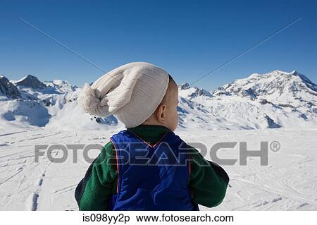 Young boy standing looking at mountains in snow View Large Photo Image Stock Photography - Young boy standing looking at mountains in snow. Fotosearch