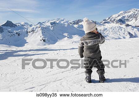 Young boy standing looking at mountains in snow View Large Photo Image Stock Photography - Young boy standing looking at mountains in snow. Fotosearch