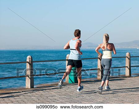 Picture - Young couple running by sea. Fotosearch