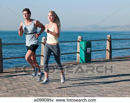 Young couple running by sea View Large Photo Image Stock Photo - Young couple running by sea. Fotosearch