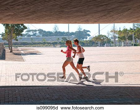 Stock Image - Young couple running. Fotosearch