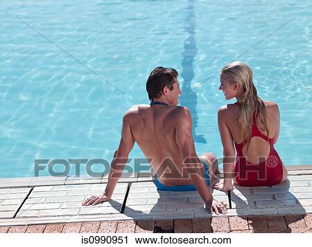 Young couple sitting at poolside View Large Photo Image Stock Image - Young couple sitting at poolside. Fotosearch