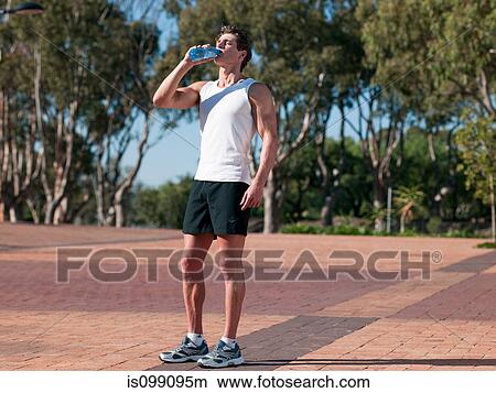 Young man drinking mineral water View Large Photo Image Picture - Young man drinking mineral water. Fotosearch