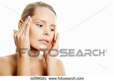 Stock Image - Young woman contemplating face lift. Fotosearch
