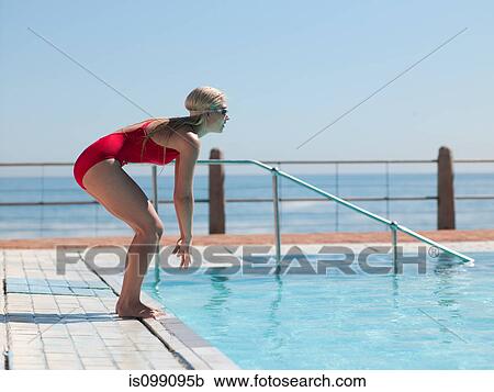 Stock Image - Young woman diving into swimming pool. Fotosearch