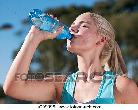Young woman drinking mineral water View Large Photo Image Stock Image - Young woman drinking mineral water. Fotosearch