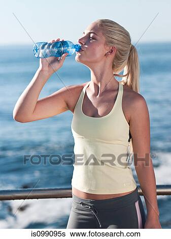 Young woman drinking mineral water View Large Photo Image Stock Photograph - Young woman drinking mineral water. Fotosearch