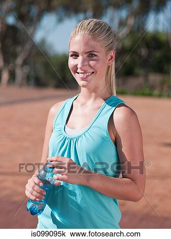 Young woman holding bottle of mineral water View Large Photo Image Stock Image - Young woman holding bottle of mineral water. Fotosearch