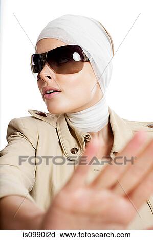 Stock Image - Young woman in sunglasses and bandages after cosmetic surgery. Fotosearch